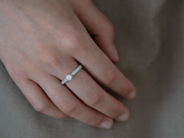 中指に婚約指輪をはめた女性の手