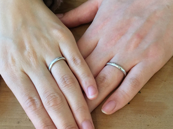 プラチナの結婚指輪をしているお二人の手