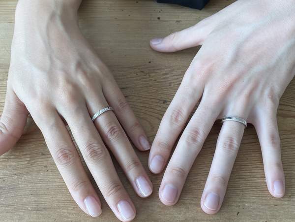 プラチナの結婚指輪をはめた男女の手
