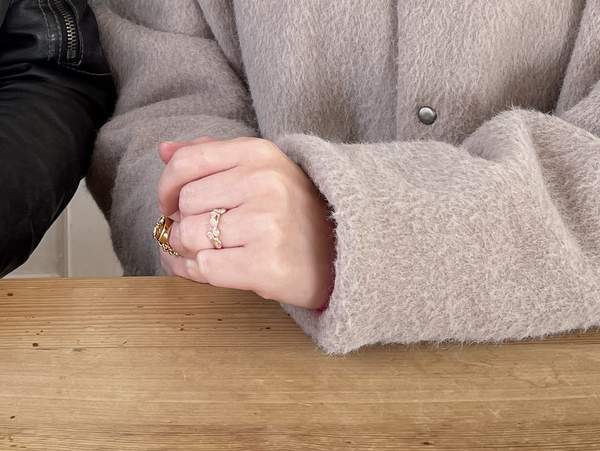 ピンクゴールドの指輪をはめた女性の手