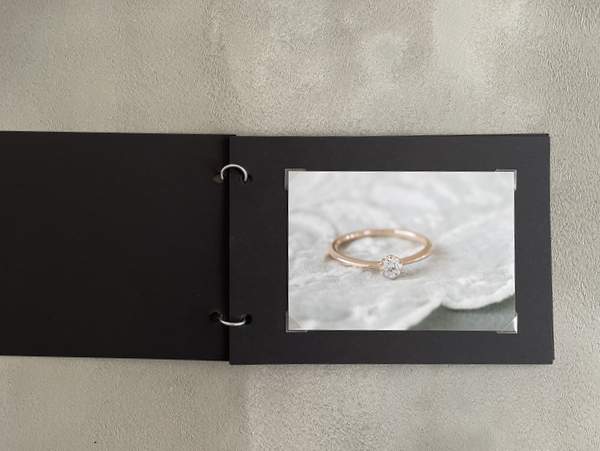 黒いフォトアルバムに貼られた指輪の写真