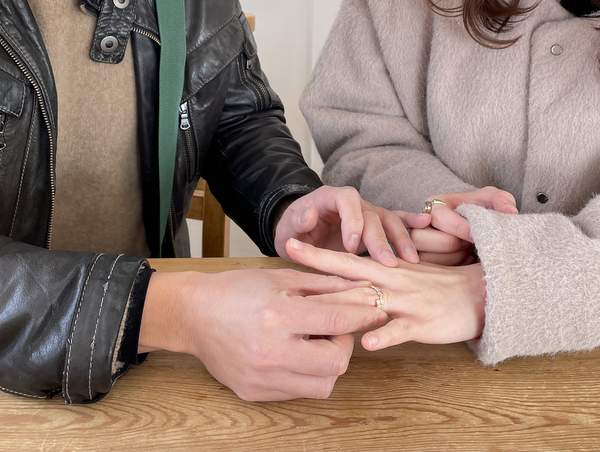 女性の手に結婚指輪を着ける男性