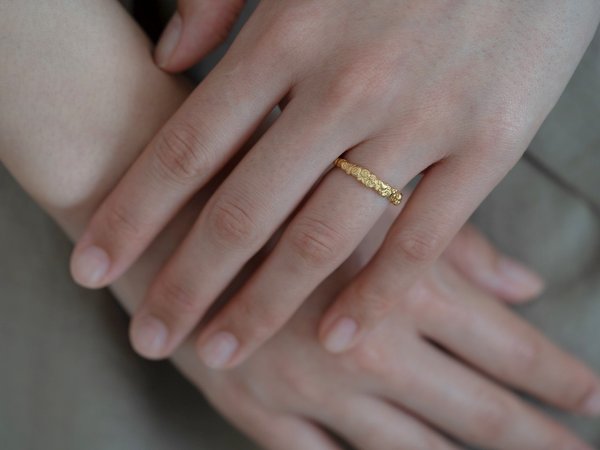 左手薬指にゴールドの結婚指輪をした女性