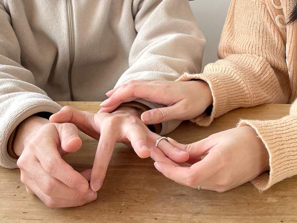 男性の手に指輪をはめる女性の手