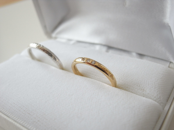 金に文字が入った指輪とシルバーの結婚指輪
