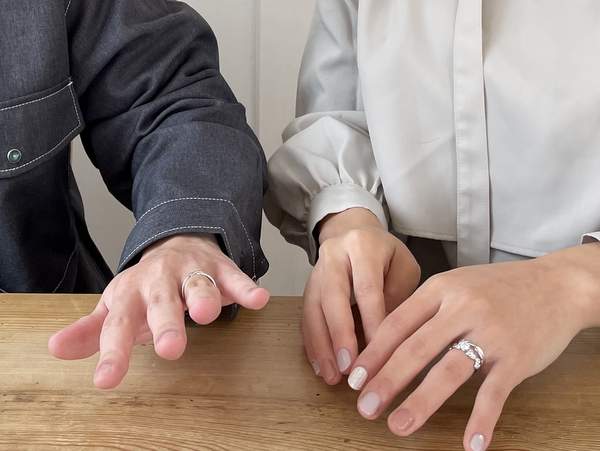 結婚指輪と婚約指輪をはめた男女の手