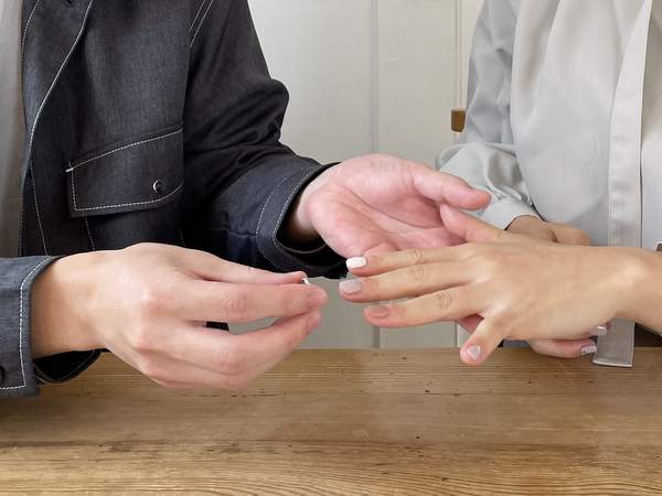 女性に結婚指輪をはめようとする男性