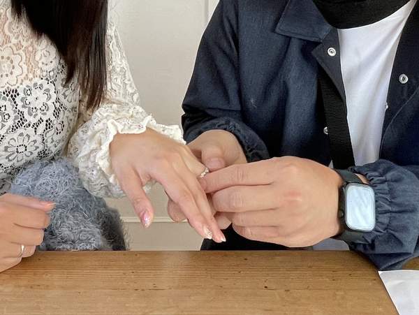 女性の手に指輪をはめる男性