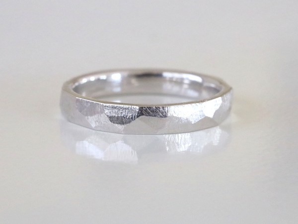 プラチナの結婚指輪で表面が面とりされている