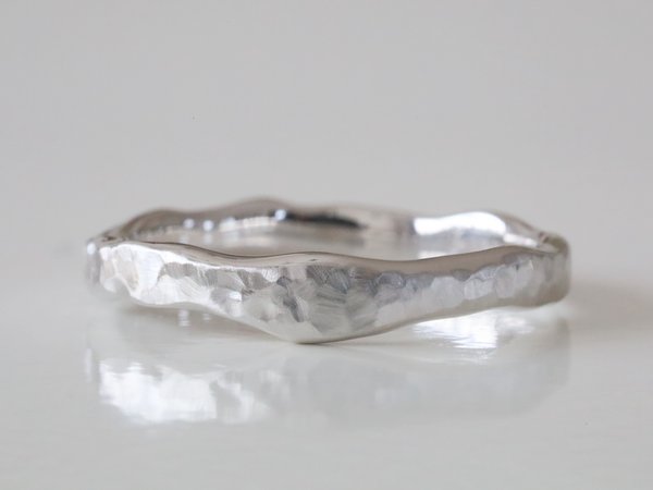 プラチナに淵が波打ったシルエットに槌目のテクスチャーの結婚指輪