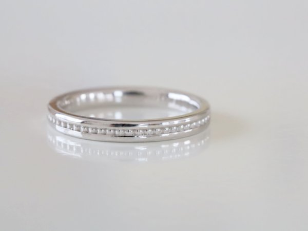 中心に丸い粒のミルグレインが入ったプラチナの結婚指輪