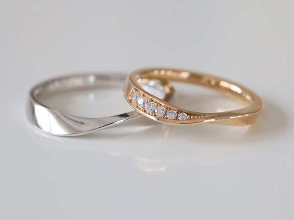 中央がねじったようなデザインのプラチナと金の結婚指輪