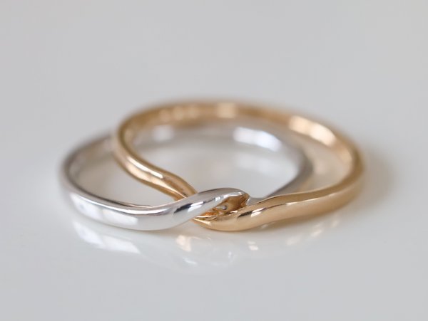ゴールドとプラチナのリングが離れることなくっついて１本になった結婚指輪