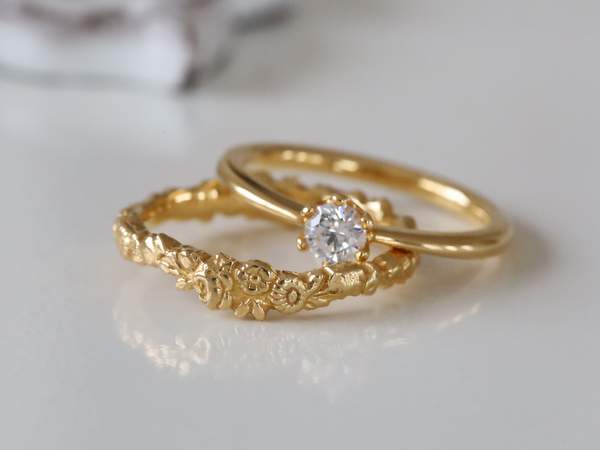 イエローゴールドの花冠デザインの結婚指輪と一粒ダイヤのソリテールの婚約指輪