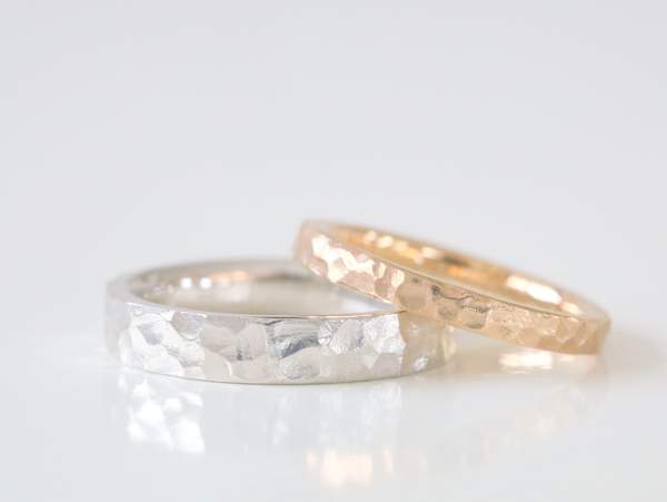 槌目のテクスチャーによって輝くプラチナとゴールドの結婚指輪