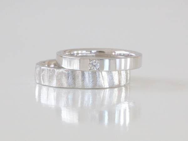 プラチナ平打ちにヤスリ目とメレーダーやモンドが石留されたシンプルな結婚指輪