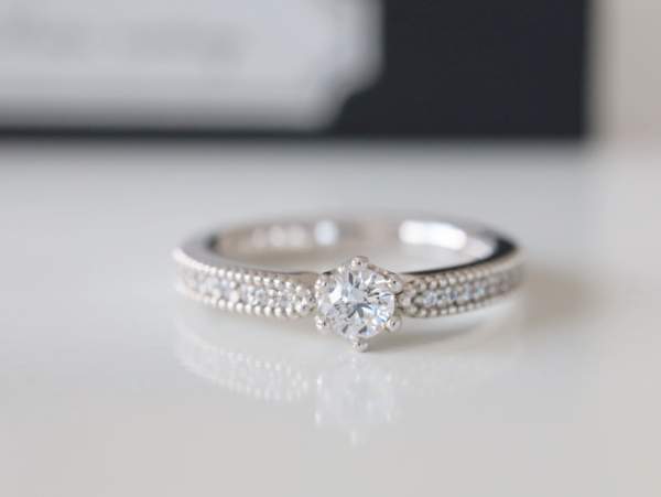プラチナリングの中央に大きめダイヤ、その両脇にメレ―ダイヤモンドが石留された婚約指輪