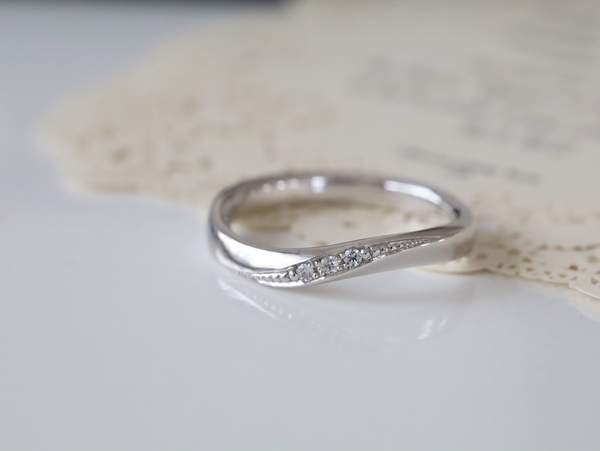 Ｓ字にねじりが入りメレ―ダイヤモンドが彫留めされたプラチナの指輪