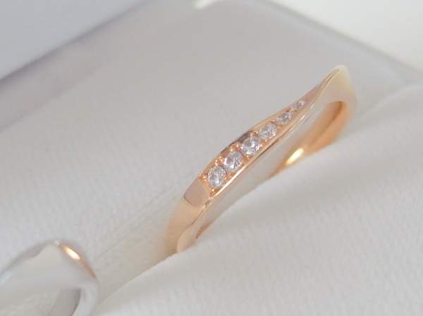 ピンクゴールドでリング中央がねじったようなデザインのメレ―ダイヤモンド入り結婚指輪