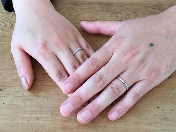 プラチナの結婚指輪をはめた男性女性のお客様の手