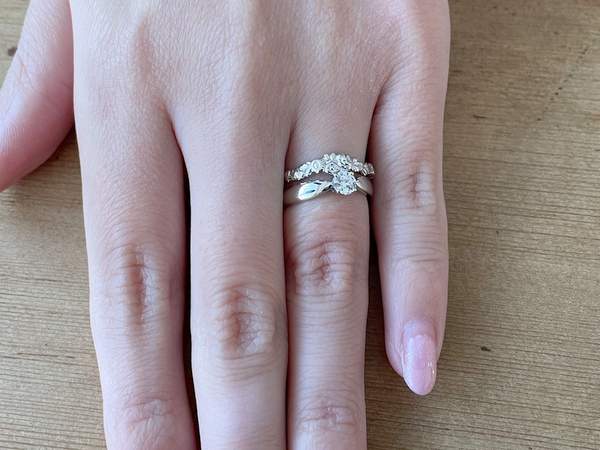 プラチナの婚約指輪と結婚指輪を重ねづけした手