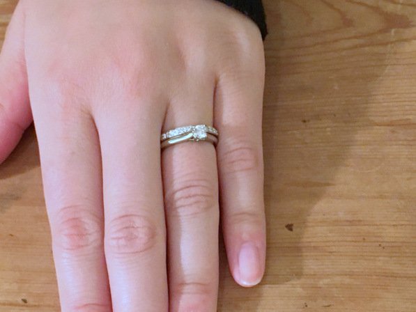 結婚指輪と婚約指輪を重ねた女性の手